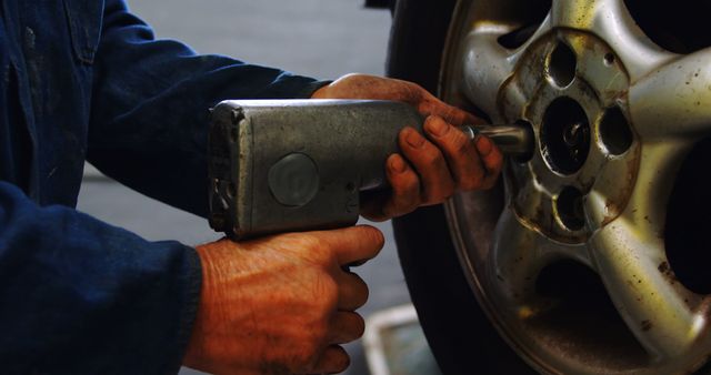 Mechanic Fixing Car Wheel Using Impact Wrench in Garage - Download Free Stock Images Pikwizard.com