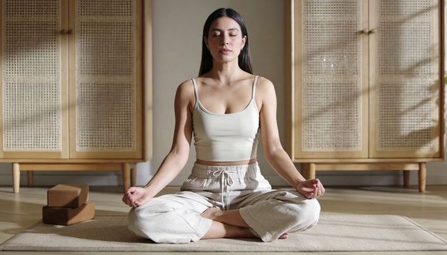 Sunlit minimalist meditation practicing mindfulness in neutral interior
