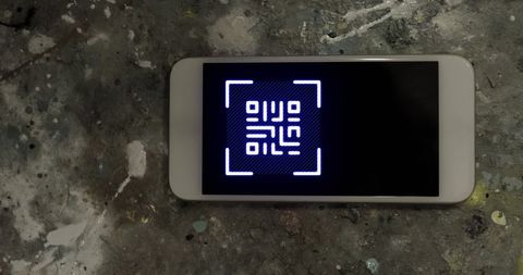 Digital qr code on smartphone display on dark surface