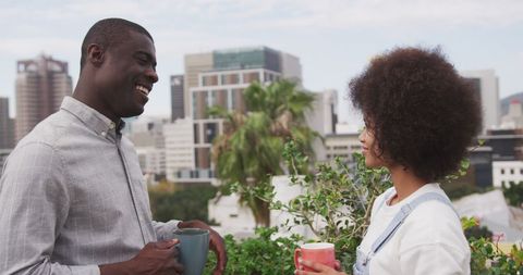 Diverse Couple Enjoying Coffee Chat on Urban Rooftop