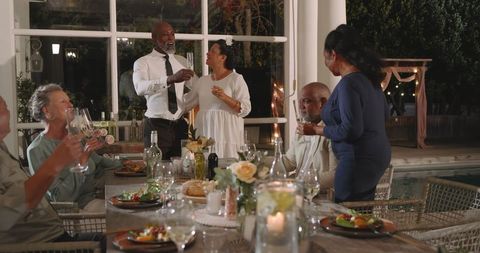 Senior friends celebrating wedding with elegant outdoor dinner