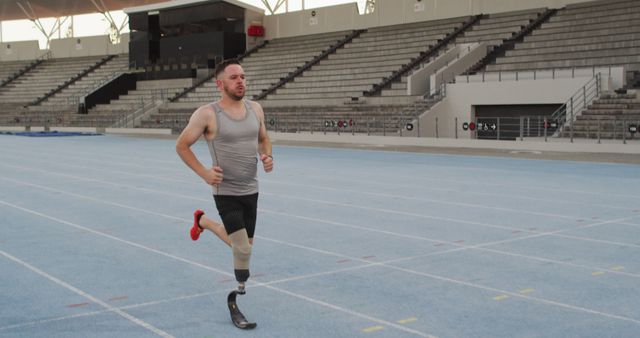 Caucasian disabled male athlete with running blade training and running. professional runner training at sports stadium.