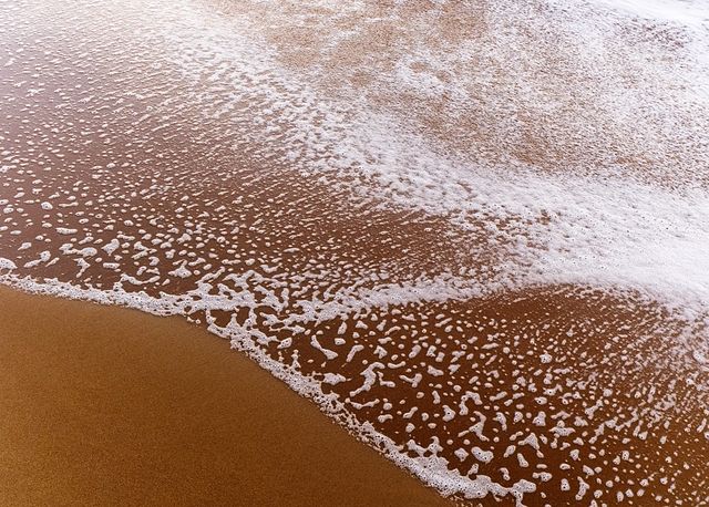 Gentle Ocean Wave Receding on Sandy Beach - Download Free Stock Photos Pikwizard.com