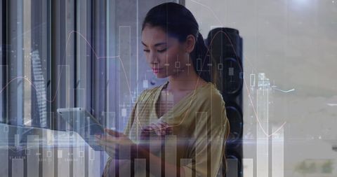 Businesswoman Analyzing Data on Digital Tablet with Financial Graphs