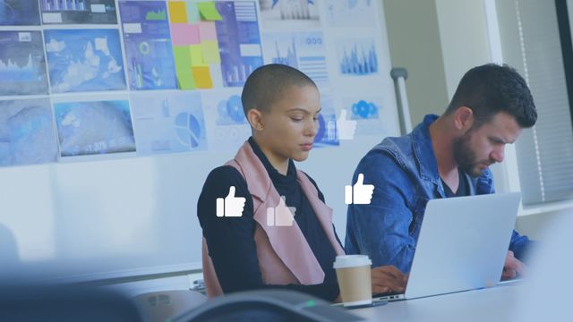 Two professionals working together at an office desk with a gentle animation of floating like icons. This representation of online engagement, digital networking, and social media integration is perfect for illustrating contemporary workplaces embracing modern technologies. Useful for content on digital marketing, office dynamics, tech-savvy business environments, and collaborative teamwork with a focus on social trends.