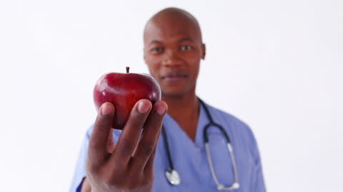 Healthcare Professional Holding Apple in Focus