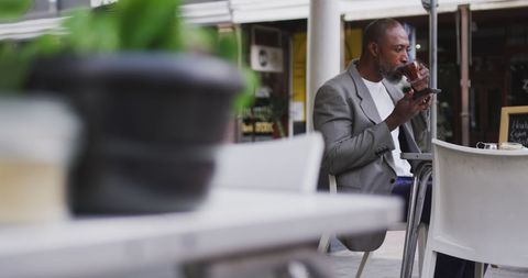 African American Man Enjoying Coffee and Smartphone at Outdoor Cafe - Download Free Stock Images Pikwizard.com