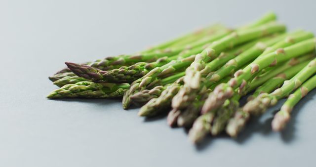 Image of close up of fresh asparagus over grey background. fusion food, fresh vegetables and healthy eating concept.