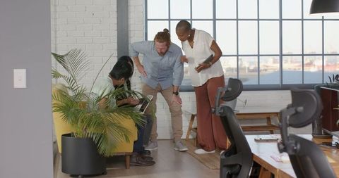 Diverse Team Collaborating in Modern Office on Tablet