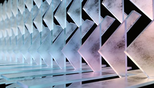 Frosted chevron panels reflecting cyan pink light in geometric art installation