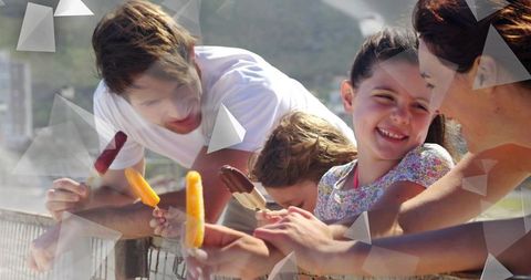 Family enjoying popsicles on sunny seaside promenade with smiling children, geometric overlay