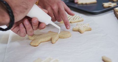Hands Decorating Christmas Cookies with Icing in Festive Atmosphere - Download Free Stock Images Pikwizard.com