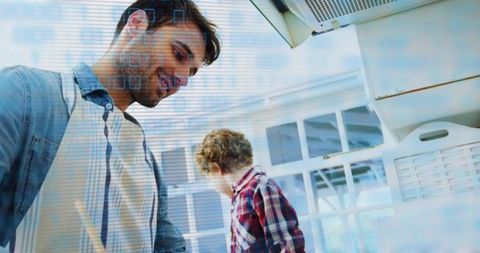 Father guiding son in bright kitchen during cooking lesson bonding learning home life