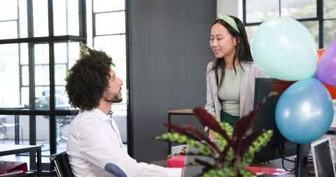 Diverse colleagues celebrating office party with gift exchange