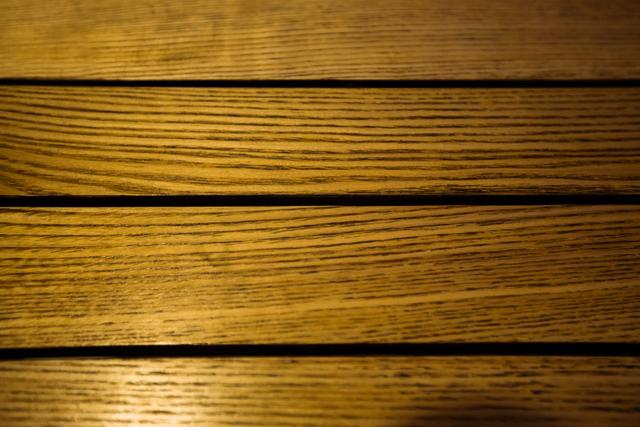 This image showcases a close-up view of wooden planks with a natural grain pattern. The warm brown tones and rustic texture make it ideal for use in backgrounds, website headers, or design projects related to construction, carpentry, or interior design. It can also be used in presentations, advertisements, or as a texture overlay in graphic design.