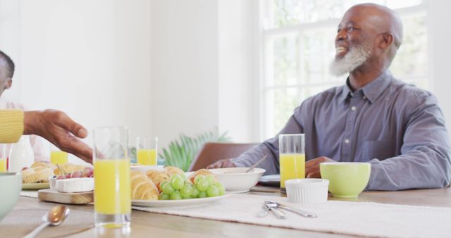 Senior African American man enjoying breakfast with family at home - Download Free Stock Images Pikwizard.com