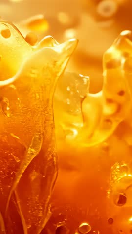 Shimmering Amber Resin Macro Vertical Video Showing Viscous Syrup Texture and Floating Bubbles