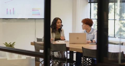 Diverse Business Colleagues Discussing Strategy in Modern Office Environment