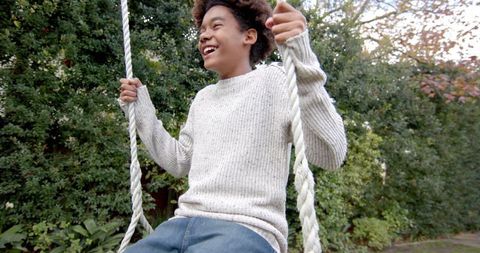 Child Joyfully Swinging on Tree Swing Surrounded by Nature - Download Free Stock Images Pikwizard.com