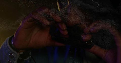 Musician playing harmonica under purple amber lights