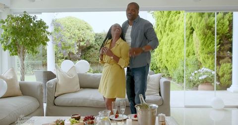 Joyful African American Couple Celebrating at Home in Stylish Living Room