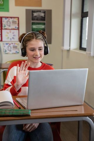 Pre-Teen Student Using Laptop and Headphones in Classroom