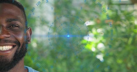 Smiling man headshot with circular hud overlay, outdoor garden bokeh, light blue knit