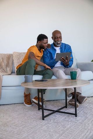 Father and Son Bonding over Tablet on Cozy Sofa