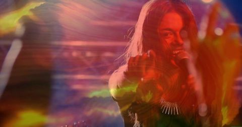Dynamic female singer performing on stage with vibrant lighting effects