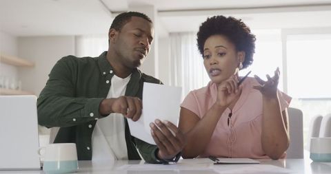 Friends Collaborating on Financial Documents at Home