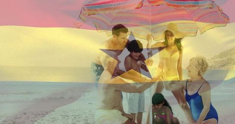 Multigenerational family enjoying beach day under colorful striped umbrella with flag overlay