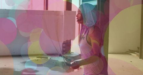 Energetic african american woman jumping rope with colorful lights overlay