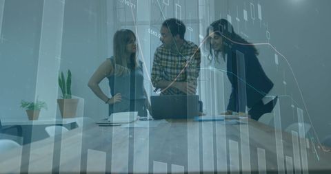Professionals analyzing financial graphs on laptop in office environment
