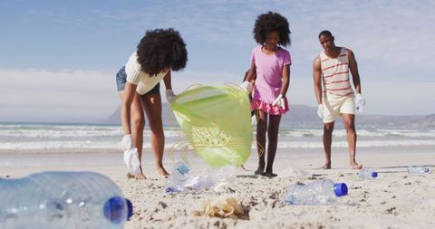 Diverse Volunteers Cleaning up Beach Litter for Environmental Conservation
