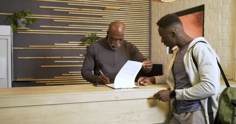 Receptionist assisting client with document review in modern office
