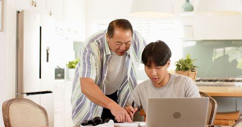 Father Mentoring Son in Contemporary Kitchen