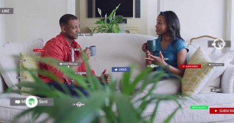 Couple having casual conversation on sofa sipping coffee with floating social media icons