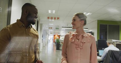 Coworkers Engaged in Conversation in Modern Office Corridor