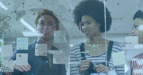 Creative Diverse Team Brainstorming with Ideas on Glass Board