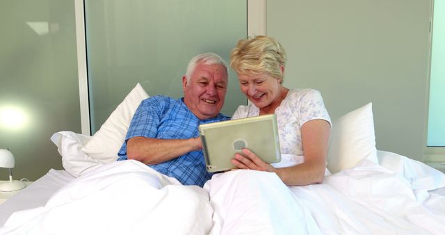 Happy Senior Couple Using Tablet in Bed - Download Free Stock Images Pikwizard.com