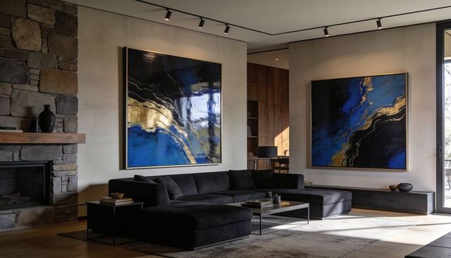 Modern living room featuring black l-shaped sectional sofa, stone fireplace, blue-gold art