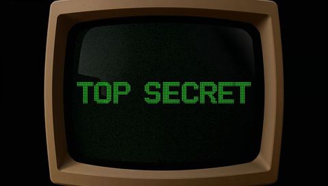 Retro crt monitor displaying neon green top secret text on dark background