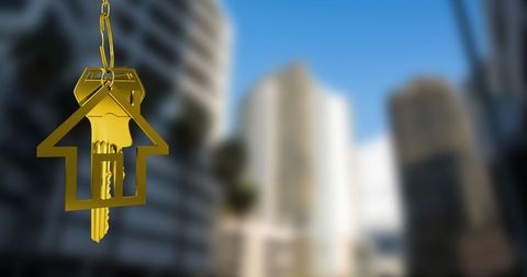 Golden House Key Against Blurred Urban Skyline
