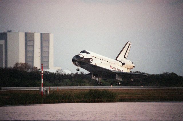 Space Shuttle Endeavour finishing a mission at Kennedy Space Center during sunset with Vehicle Assembly Building in background. Ideal for topics on space exploration, aviation history, and space shuttle programs. Useful for educational content, presentations, documentaries, and articles related to NASA missions or historic moments in spaceflight.
