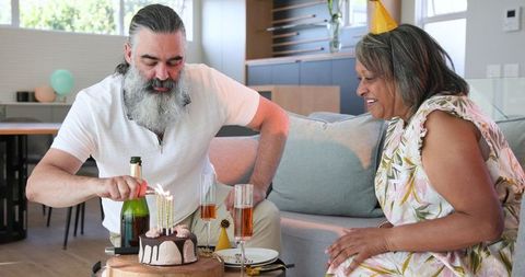 Senior Couple Celebrating with Birthday Cake and Champagne