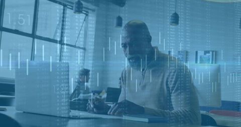 Professional typing on laptop with financial data analytics overlay in coworking space