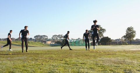 Male Athletes Engaging in Outdoor Fitness Drills on Grass Field