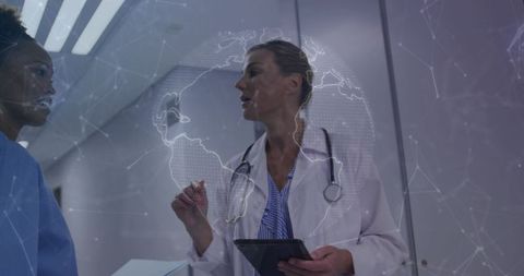 Doctor and nurse collaborating with tablet and globe network overlay in hospital corridor