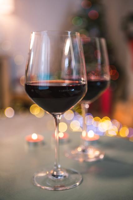 Two Glasses of Red Wine with Festive Christmas Lights - Download Free Stock Photos Pikwizard.com