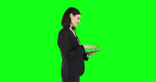 Businesswoman using tablet with green screen background. Could be used for themes related to technology, business communication, digital agendas, and corporate presentations. Suitable for promotional materials, websites, or advertisements in professional and modern business contexts.